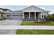 Beautiful home with landscaped front yard, stone accents, a covered porch and a three-car garage at 14523 Swiss Bridge Dr, Lithia, FL 33547