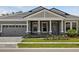 Charming single-story home showcasing a well-manicured lawn, stone accents, and an attached two-car garage at 14523 Swiss Bridge Dr, Lithia, FL 33547