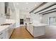 Modern kitchen boasts an island with a marble countertop, ample white cabinetry, and stainless steel appliances at 14523 Swiss Bridge Dr, Lithia, FL 33547