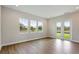 Bright living room with hardwood floors, large windows, and doors leading to the outdoors at 14523 Swiss Bridge Dr, Lithia, FL 33547