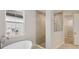 Modern bathroom featuring a soaking tub, glass-enclosed shower, and neutral tile at 14531 Swiss Bridge Dr, Lithia, FL 33547