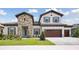 Beautiful two-story home featuring a stone facade, symmetrical design, and a well-manicured lawn at 14531 Swiss Bridge Dr, Lithia, FL 33547