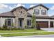 Charming two-story home featuring a stone facade, well-maintained landscaping, and a three-car garage at 14531 Swiss Bridge Dr, Lithia, FL 33547