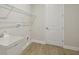 Functional laundry room featuring vinyl floors, utility sink, and wire shelving at 14531 Swiss Bridge Dr, Lithia, FL 33547