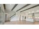 Open-concept living space featuring wood beams, staircase, kitchen, and sliding glass doors at 14531 Swiss Bridge Dr, Lithia, FL 33547