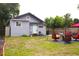 A spacious backyard featuring well-maintained grass, outdoor seating, and a grey house with a light-blue door at 1510 Mobile Ave, Tampa, FL 33610