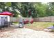 A spacious backyard with a BBQ grill, outdoor seating areas, and a mix of gravel and grassy surfaces at 1510 Mobile Ave, Tampa, FL 33610