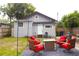 Landscaped backyard featuring a stone patio with outdoor seating, a lush lawn, and a grey house at 1510 Mobile Ave, Tampa, FL 33610
