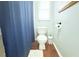 Bathroom with toilet, blue shower curtain, and accent wall at 1510 Mobile Ave, Tampa, FL 33610