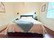Bedroom with wood floors, natural light from the window, and modern lamps at 1510 Mobile Ave, Tampa, FL 33610
