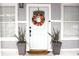 Charming front door with a wreath, flanked by plants at 1510 Mobile Ave, Tampa, FL 33610
