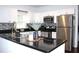 Updated kitchen with white cabinets, black countertops, and stainless steel appliances at 1510 Mobile Ave, Tampa, FL 33610