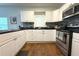 Bright kitchen with white cabinets, stainless steel appliances, and dark countertops at 1510 Mobile Ave, Tampa, FL 33610