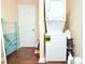 Laundry area featuring a stacked washer and dryer, along with a folding rack and a white exterior door at 1510 Mobile Ave, Tampa, FL 33610