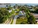 Aerial view of a beautiful blue home surrounded by palm trees, showcasing its well-maintained yard and scenic location at 160 Shore Dr, Palm Harbor, FL 34683