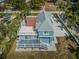Expansive aerial view of a blue two-story home with a spacious rooftop deck, showcasing the property's unique design and curb appeal at 160 Shore Dr, Palm Harbor, FL 34683