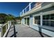 A spacious deck with modern cable railing offers picturesque views of the surrounding landscape and clear blue sky at 160 Shore Dr, Palm Harbor, FL 34683