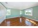 Bright bedroom with light green walls, hardwood floors, and sunny windows at 160 Shore Dr, Palm Harbor, FL 34683