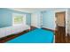 Bright blue bedroom with hardwood floors, closet, and a window at 160 Shore Dr, Palm Harbor, FL 34683
