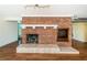 Living room with exposed brick fireplace and hardwood floors at 160 Shore Dr, Palm Harbor, FL 34683