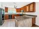 Stylish kitchen with granite countertops, stainless appliances, tile floor, and custom wood cabinetry at 160 Shore Dr, Palm Harbor, FL 34683