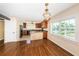 Open floor plan with kitchen, dining area, and living area, featuring hardwood floors and natural light at 160 Shore Dr, Palm Harbor, FL 34683