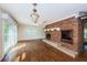 Spacious living room featuring a brick fireplace, hardwood floors, and sliding glass doors at 160 Shore Dr, Palm Harbor, FL 34683
