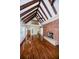 Bright living room with exposed beam ceiling, hardwood floors, brick fireplace and staircase at 160 Shore Dr, Palm Harbor, FL 34683