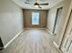 This bedroom is spacious, featuring wood-look flooring, a ceiling fan, and a window at 1878 Greenwood Valley Dr, Plant City, FL 33563