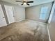 Neutral bedroom features a ceiling fan, plush carpet, a window, and a pair of closet doors at 1878 Greenwood Valley Dr, Plant City, FL 33563
