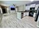 Open living space showcasing hardwood floors, integrated media center, and modern kitchen at 1878 Greenwood Valley Dr, Plant City, FL 33563