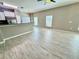 Spacious living area with wood-look floors, large windows, modern lighting, and open-concept kitchen at 1878 Greenwood Valley Dr, Plant City, FL 33563