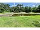 A pond with lush greenery and mature trees lining the background at 1878 Greenwood Valley Dr, Plant City, FL 33563