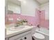 Bathroom with pink tiling, combined tub and shower, sink, and vanity at 1903 24Th St, Sarasota, FL 34234