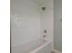 Close-up of a tub shower featuring white tile and updated fixtures at 1960 Canadiana Ct, Dunedin, FL 34698