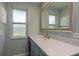 Stylish bathroom featuring blue vanity cabinets, white countertops, and a decorative mirror at 1960 Canadiana Ct, Dunedin, FL 34698
