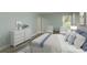 Comfortable bedroom with wood-look floors, neutral colors, dresser, and a window for natural light at 1960 Canadiana Ct, Dunedin, FL 34698