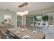 Dining room with wood table set for six, modern chandelier and access to a screened patio at 1960 Canadiana Ct, Dunedin, FL 34698