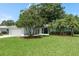 Charming single-story home featuring mature trees, well-manicured lawn, and an attached two-car garage at 1960 Canadiana Ct, Dunedin, FL 34698