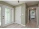 Light and airy hallway featuring wood-look floors, decorative front door and updated lighting at 1960 Canadiana Ct, Dunedin, FL 34698