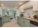 Well-lit kitchen featuring granite counters, mixed color cabinets and a tile backsplash at 1960 Canadiana Ct, Dunedin, FL 34698