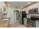 Functional kitchen with stainless steel appliances, light countertops, and tile floors at 1960 Canadiana Ct, Dunedin, FL 34698