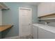 Functional laundry room with modern appliances, storage cabinets, and a folding countertop at 1960 Canadiana Ct, Dunedin, FL 34698