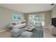 Comfortable living room featuring neutral paint, wood-look flooring and a large window for natural light at 1960 Canadiana Ct, Dunedin, FL 34698