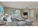 Inviting living room with neutral paint, wood-look flooring and large window for natural light at 1960 Canadiana Ct, Dunedin, FL 34698