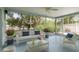 Inviting screened porch with comfortable seating and views of the landscaped yard at 1960 Canadiana Ct, Dunedin, FL 34698