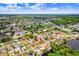 This aerial shows a waterfront community with mature landscaping and a glimpse of the ocean in the distance at 2119 Sugarbush Dr, Holiday, FL 34690