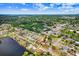 An aerial view of a home in a neighborhood surrounded by lush green trees and a lake nearby at 2119 Sugarbush Dr, Holiday, FL 34690