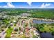 An aerial view features a well-maintained home, lush green landscaping, and a tranquil lake nearby at 2119 Sugarbush Dr, Holiday, FL 34690
