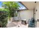 Cozy back patio with comfortable seating, decorative pavers, a shaded lounge swing, and well-maintained landscaping at 2119 Sugarbush Dr, Holiday, FL 34690